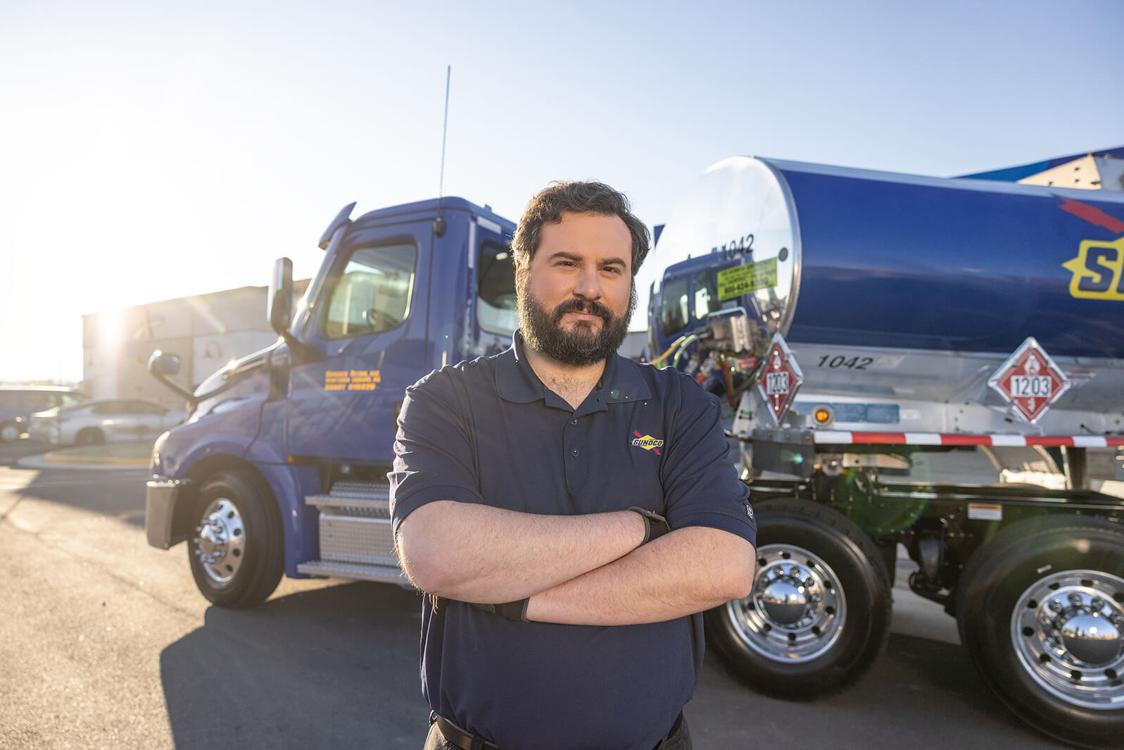 Truck driver in front of large truck smiling 