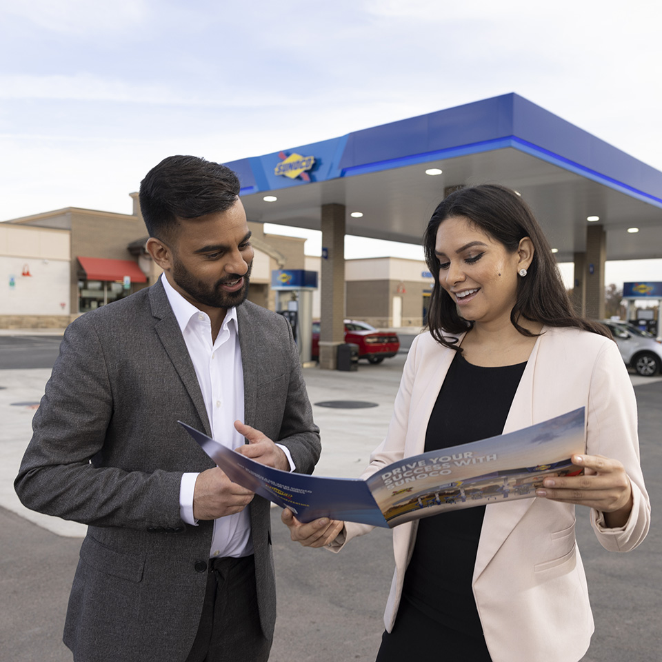 Man and woman talking outside Sunoco fuel station