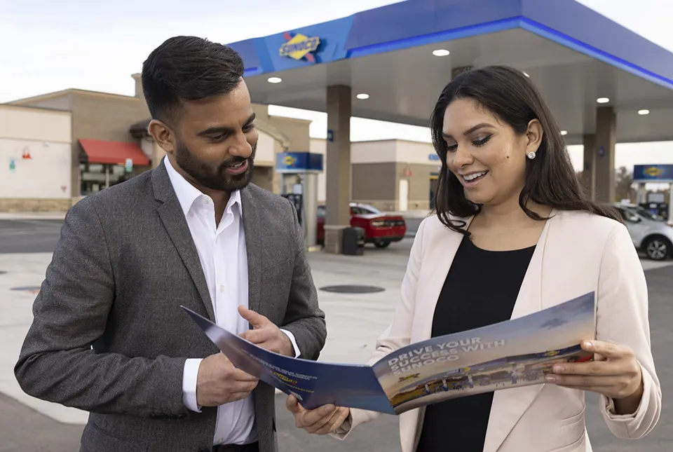 Man and woman talking outside Sunoco fuel station