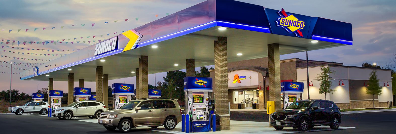 Aplus store with Sunoco branded fuel pumps at sunset