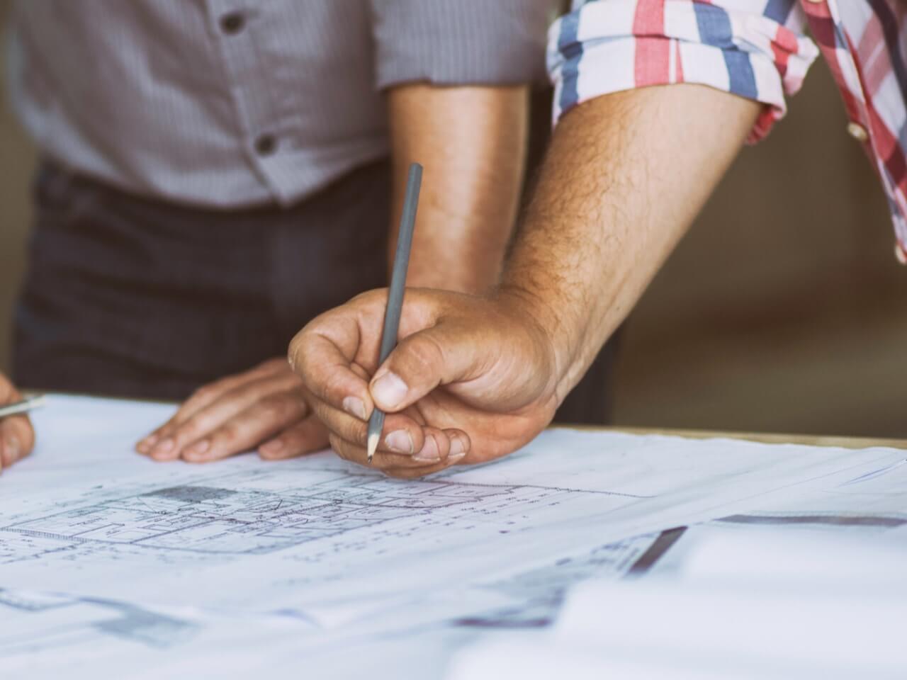 Architect with drafting pencil and blueprints